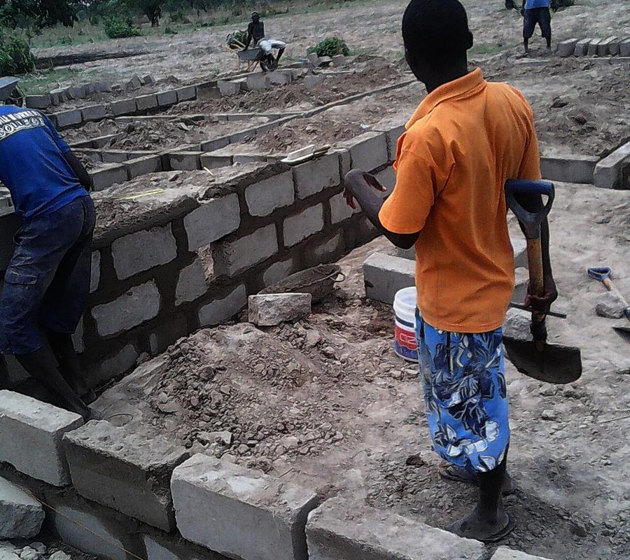 Masons laying sandcrete blocks on a building site in Tamale