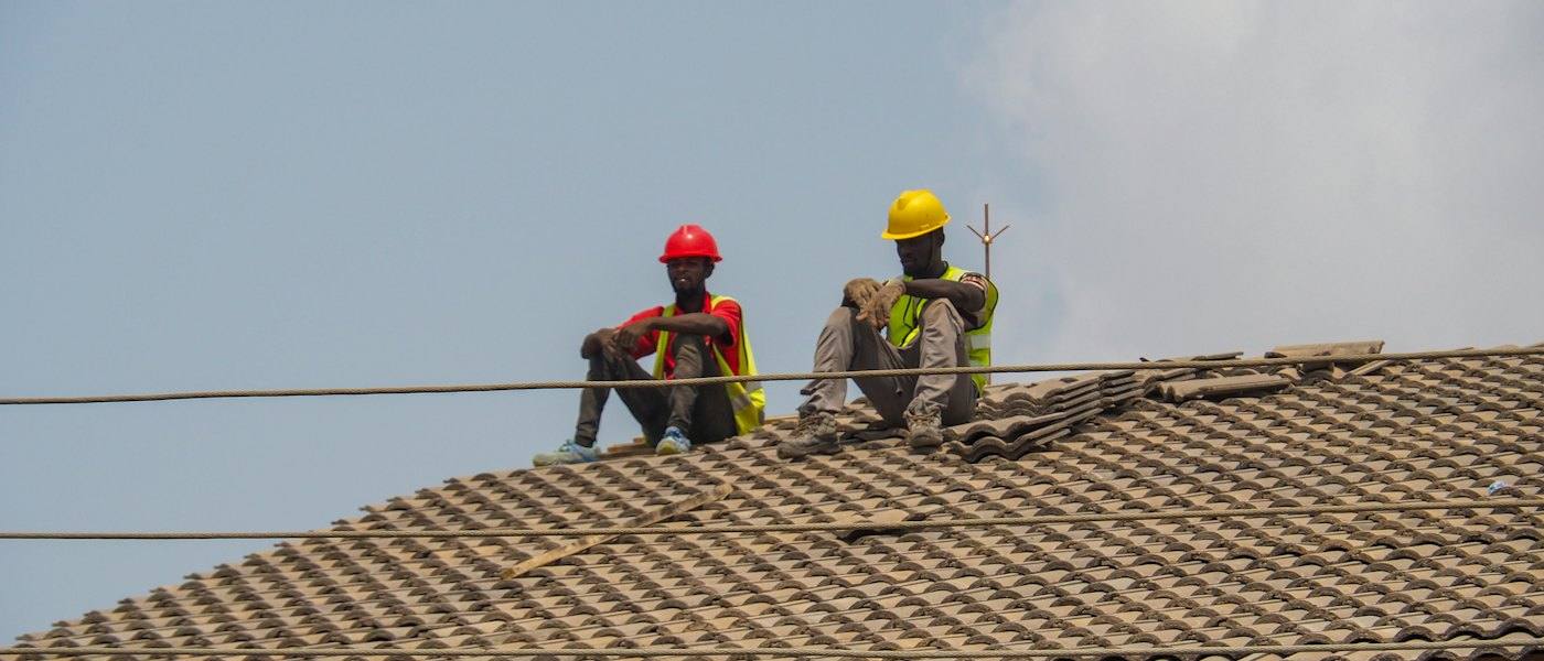 Two workers on a tiled roof