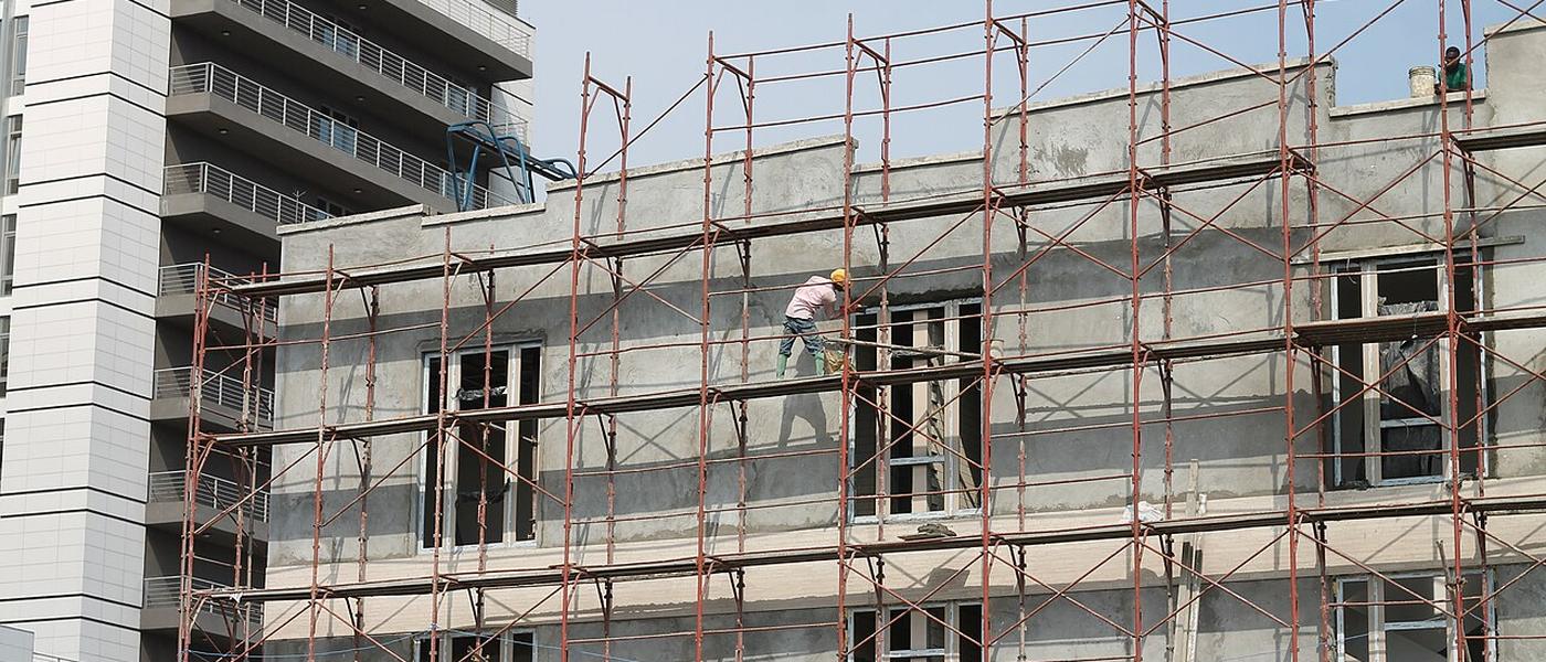 A mason working on scaffolding on a building in Accra